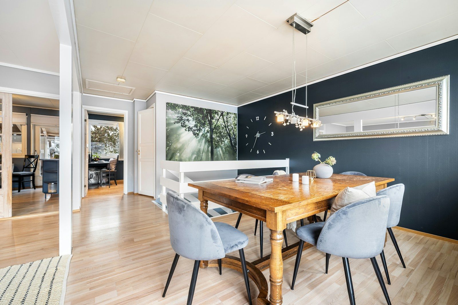 A dining room with a wooden table surrounded by blue chairs
